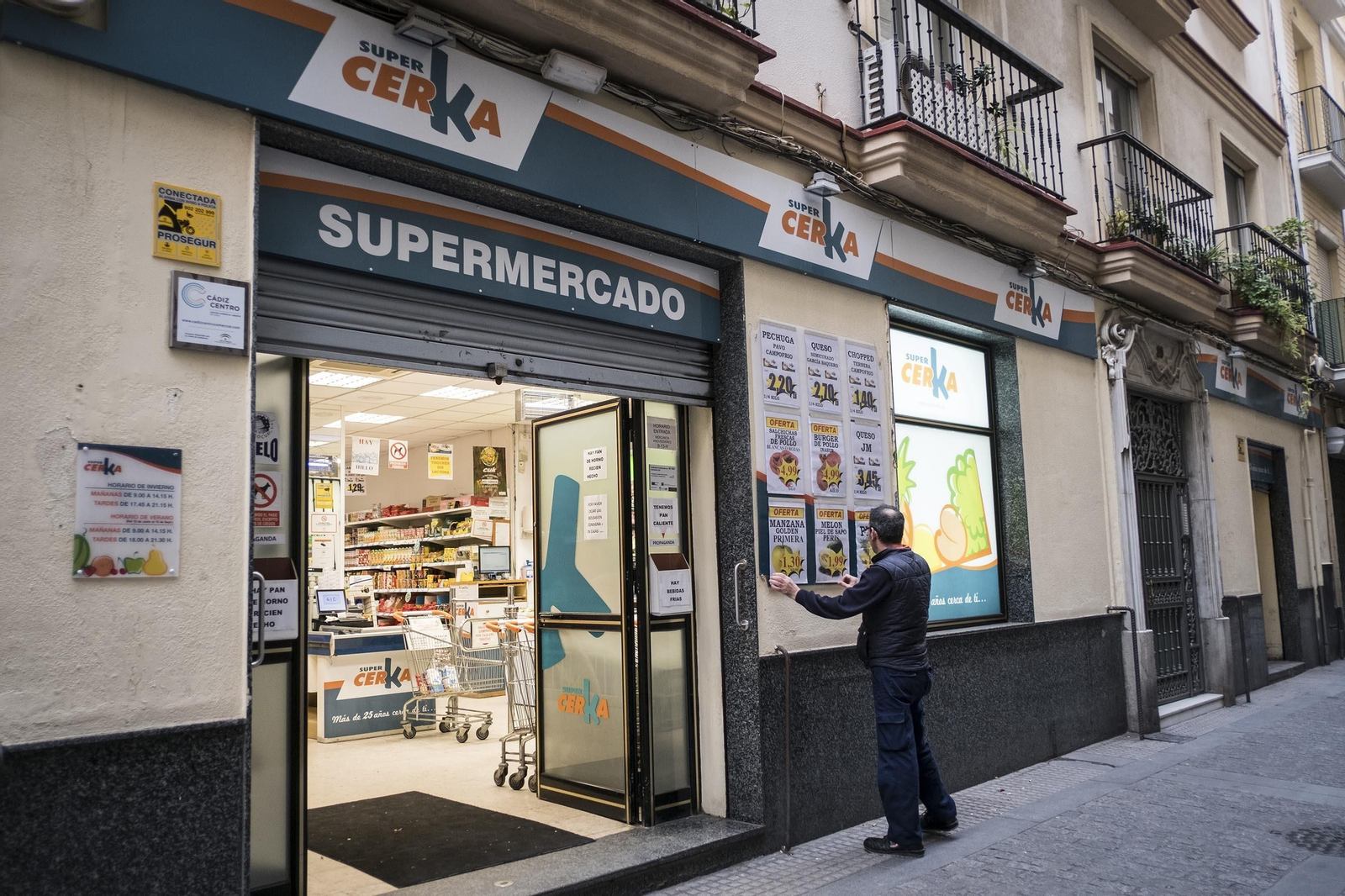 Un empleado coloca carteles en el Supercerka ubicado en la calle Enrique de las Marinas.