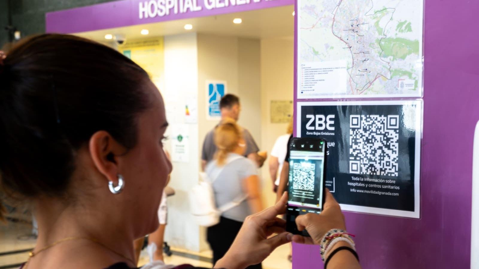 Una usuaria obtiene información de la ZBE de Granada a través del QR instalado en el Hospital Virgen de las Nieves