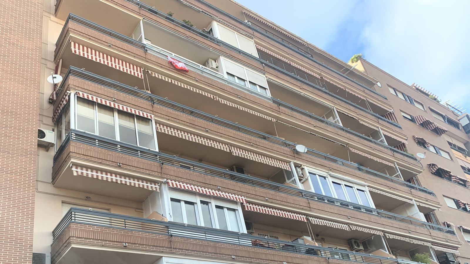 Un balcón de Granada con la bandera rojiblanca