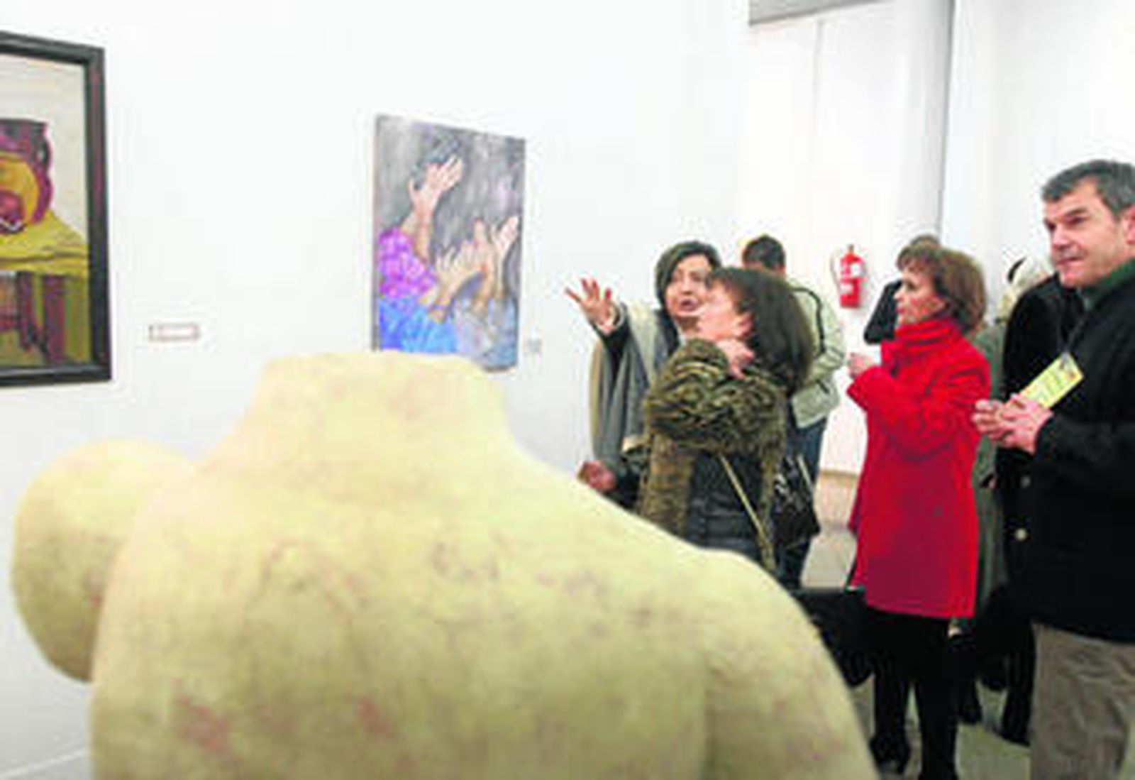 Un grupo de personas mira algunas de las obras de la exposición en la jornada inaugural.