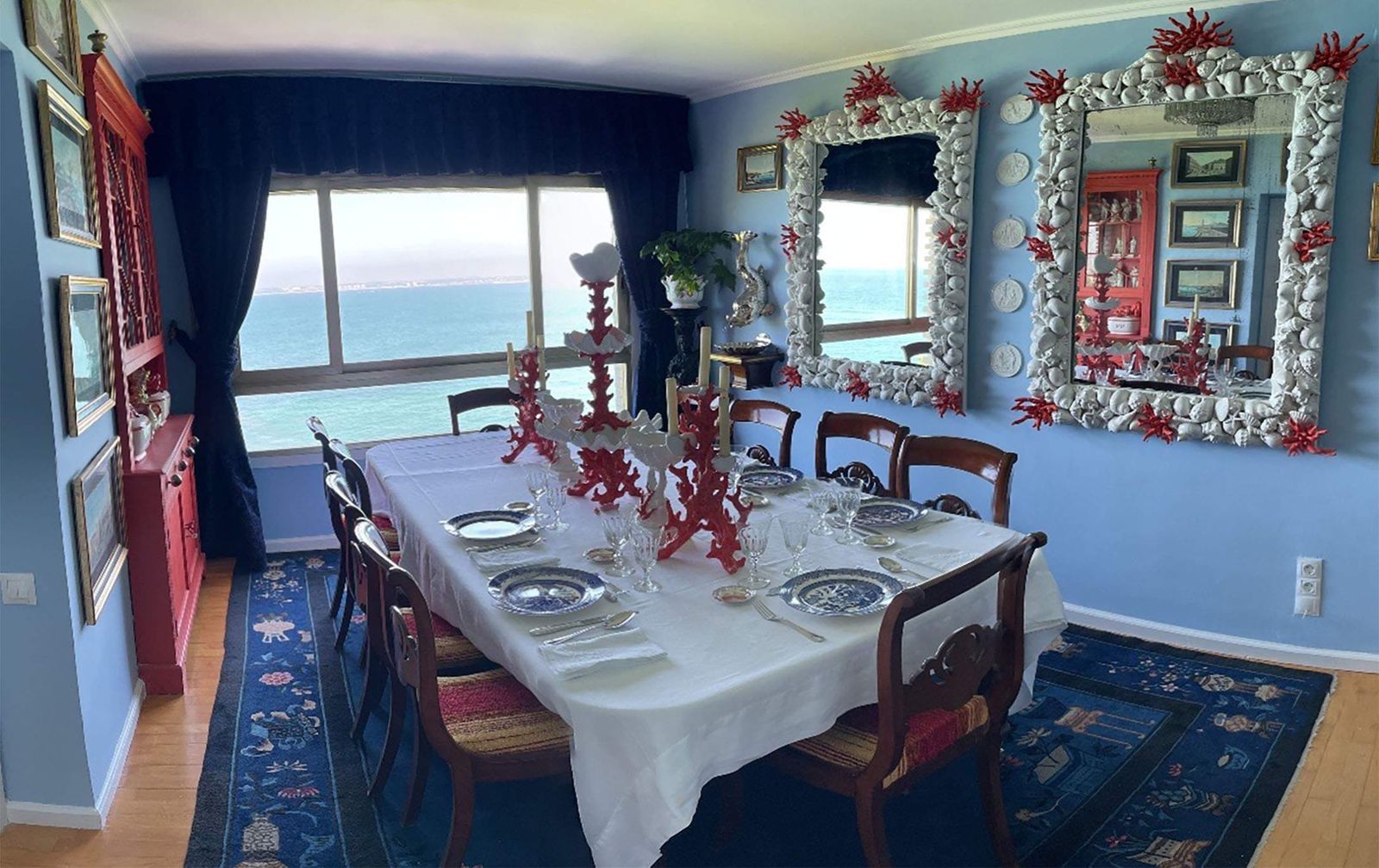 Comedor con espejos de cerámica y ventanal al mar.