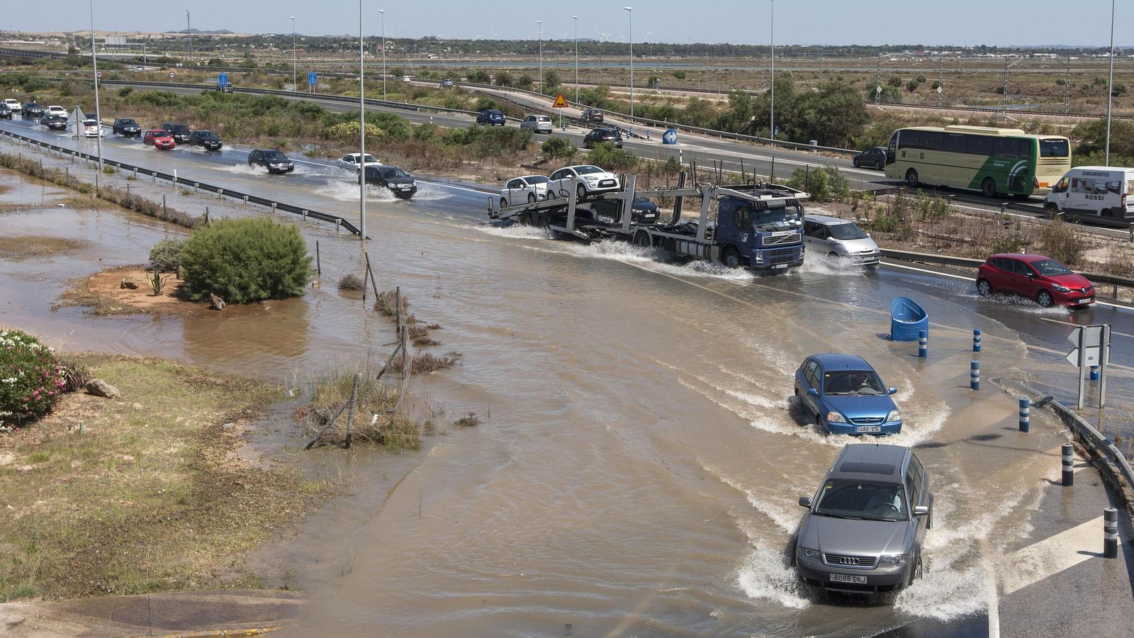 Dos coches avanzan por el charco generado tras la rotura.