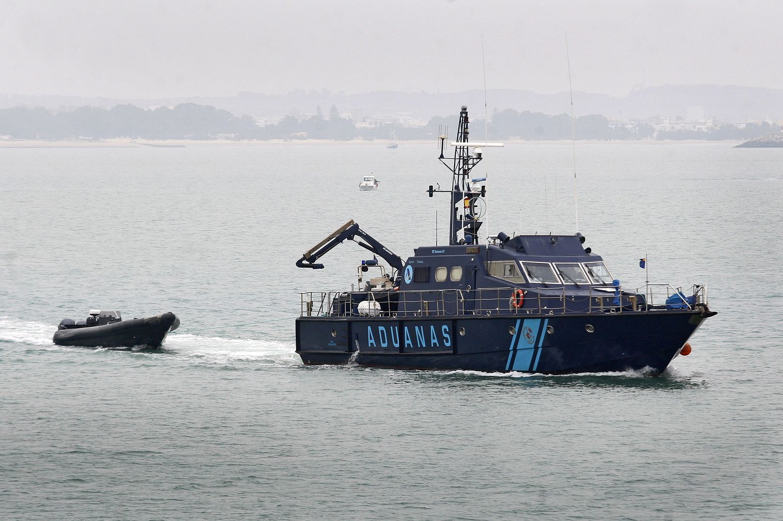 Una patrullera de Vigilancia Aduanera llega al puerto de Cádiz remolcando la embarcación.