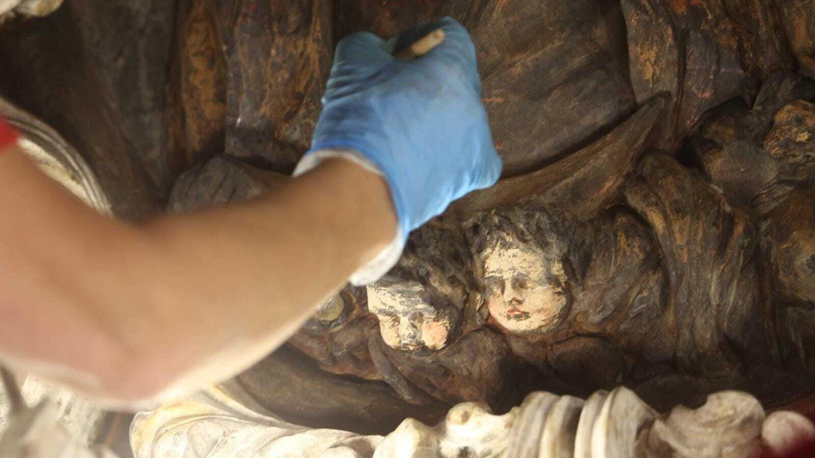 Resaturador limpiando unos 'putti' en el interior del camarín.