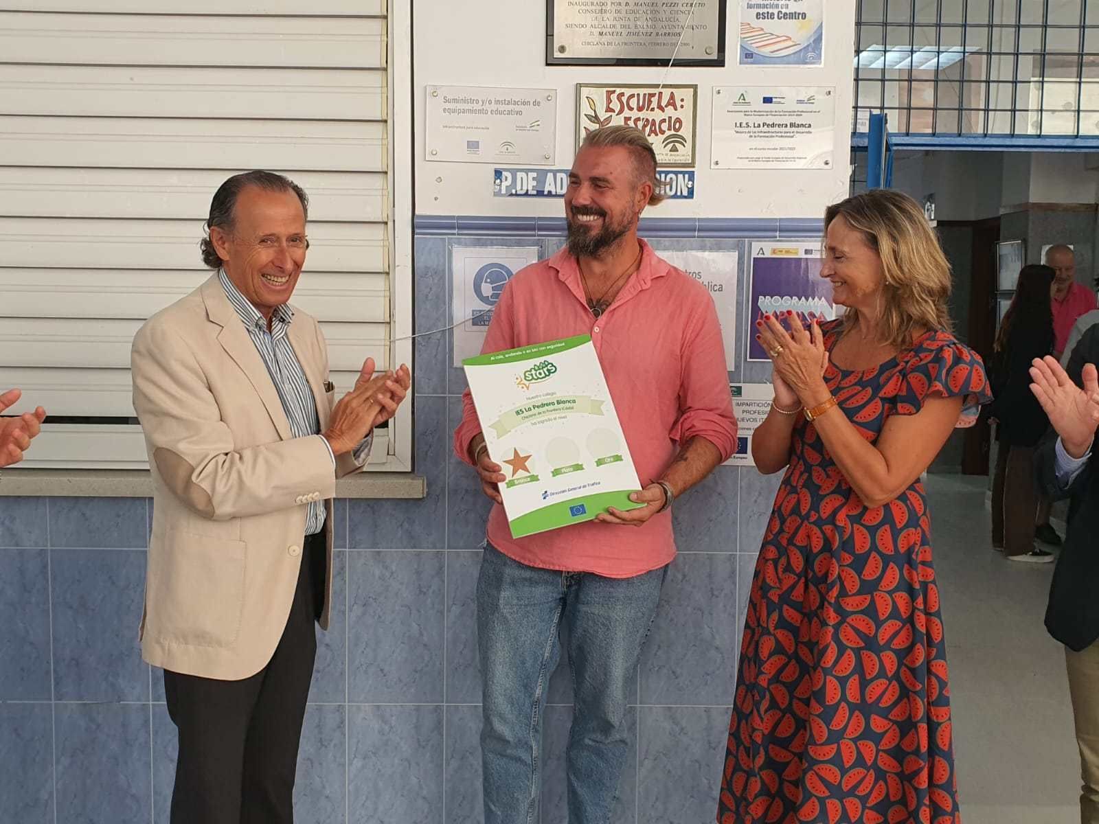 El alcalde y la jefa provincial de Tráfico entregan la placa acreditativa al director del centro educativo, por su participación en talleres e iniciativas para fomentar desplazamientos sostenibles y seguros.