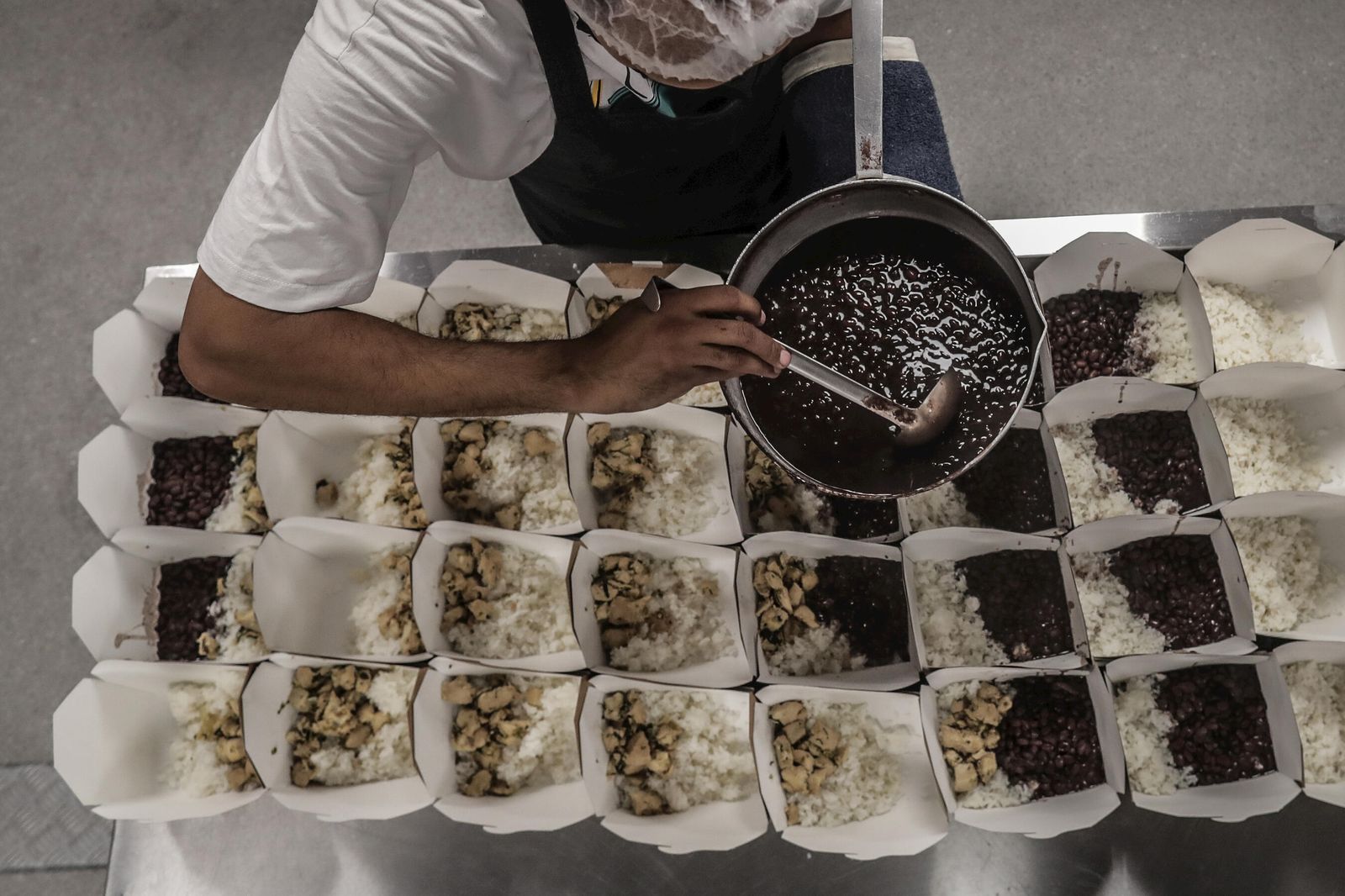 Un voluntario prepara raciones de comida para personas sin hogar en Río de Janeiro.