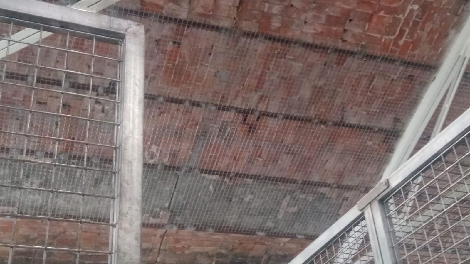 Una malla en el techo tras la caída de ladrillos.