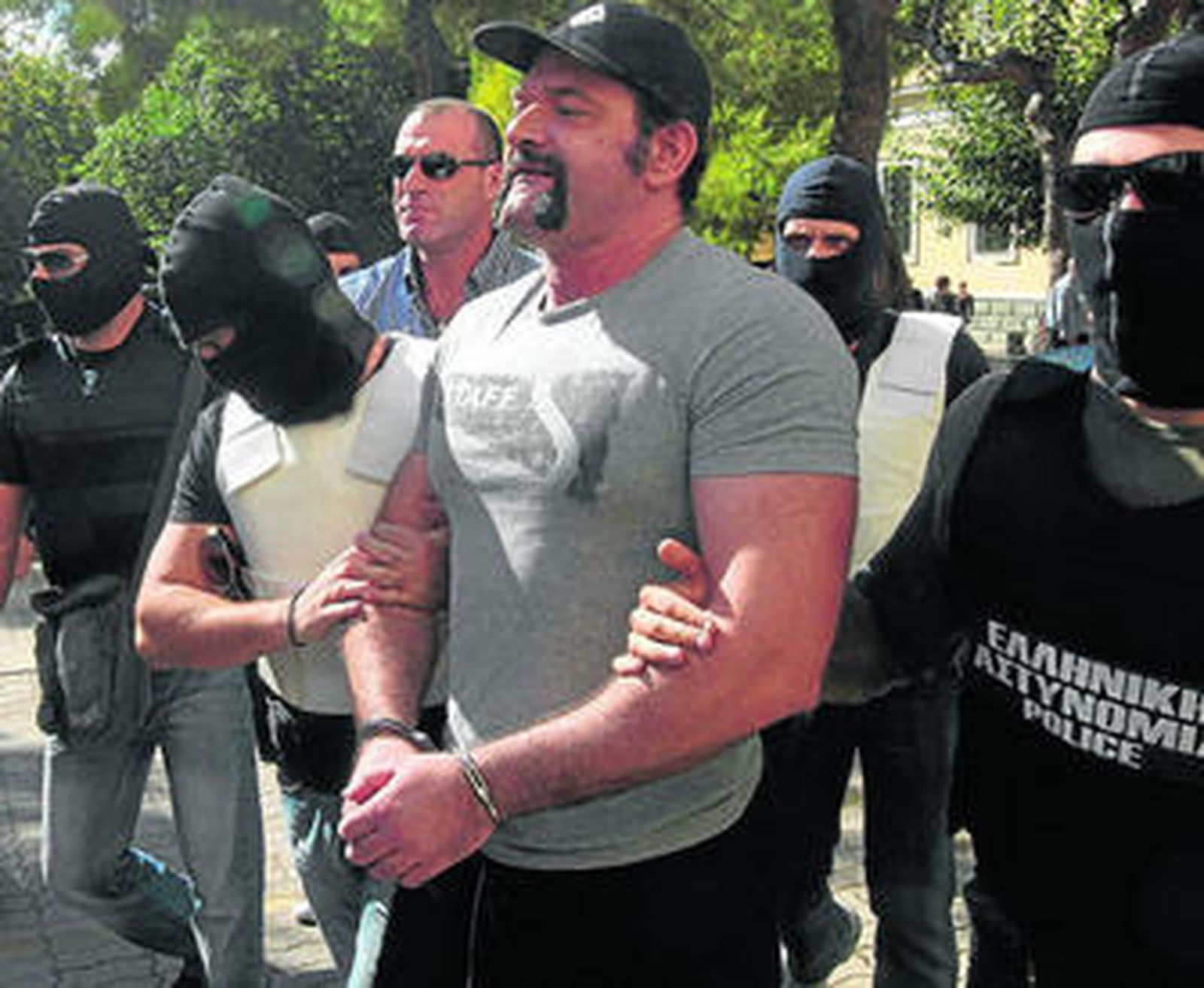 Policías antiterroristas escoltan a los dirigentes de Amanecer Dorado a la entrada en los juzgados de Atenas.