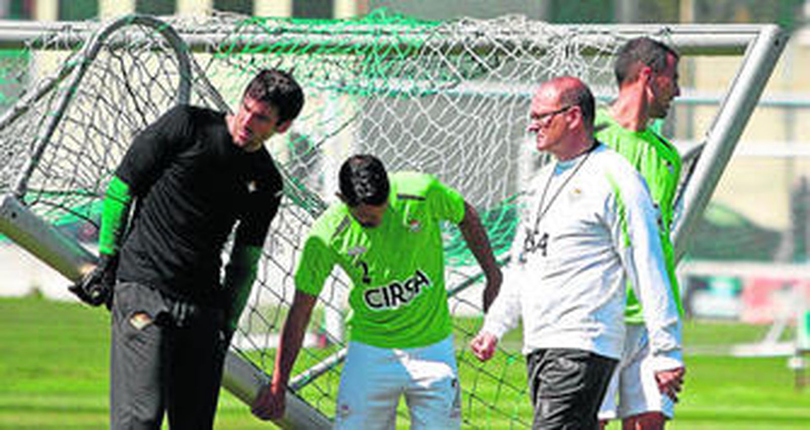 Pepe Mel pasa por delante de Goitia, Isidoro y Amaya, quienes trasladan de sitio una portería.