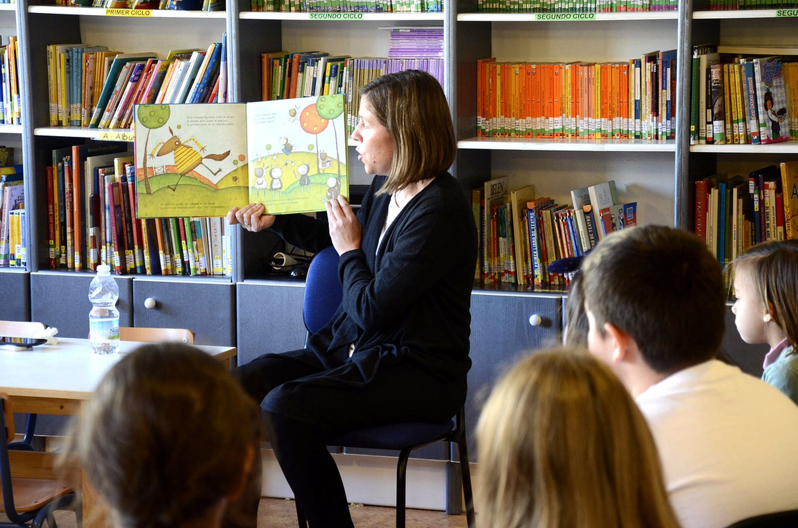 Una profesora lee un cuento a sus alumnos.