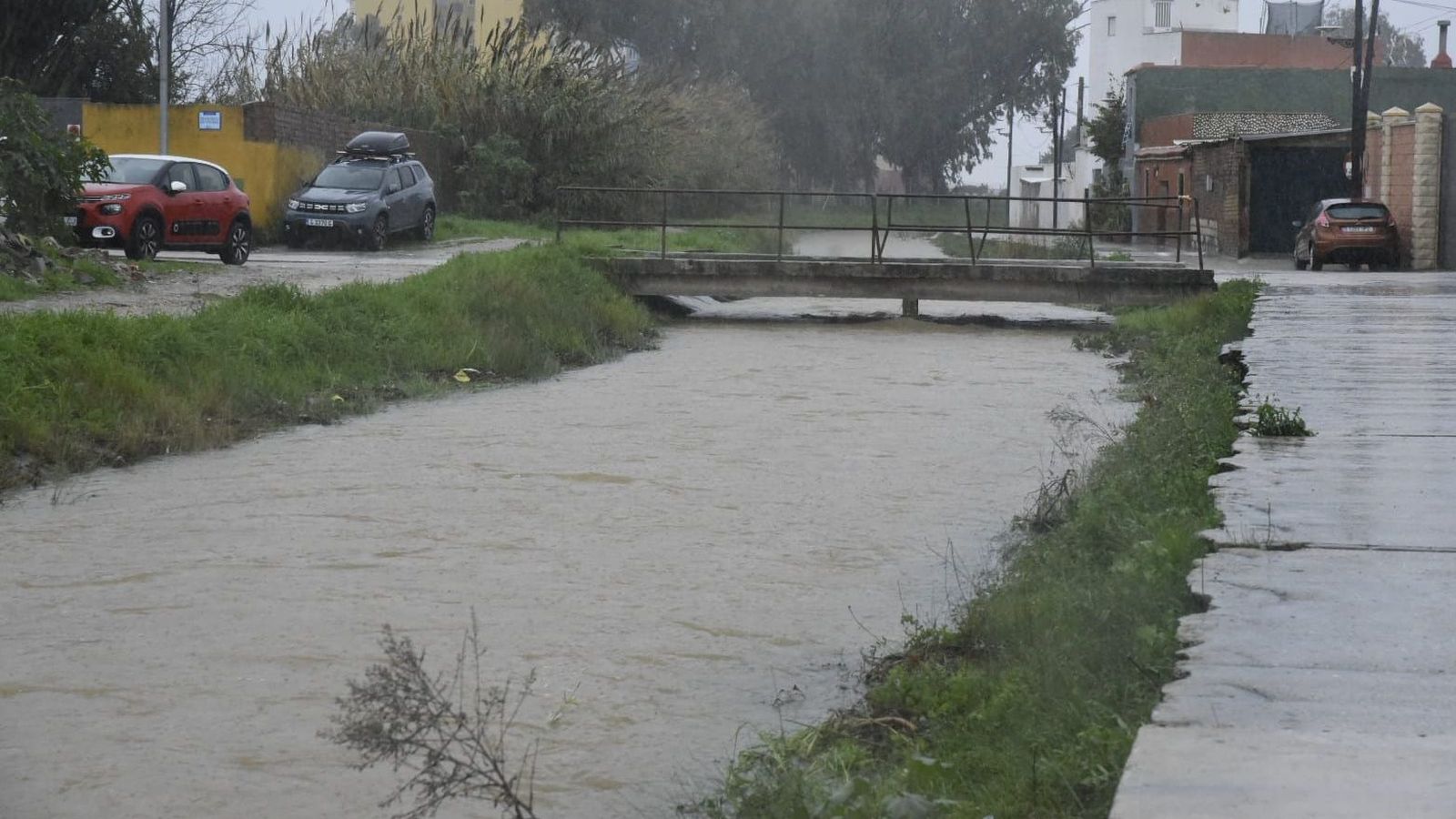 El río Cachón, en el límite de La Línea y San Roque, cargado de agua a primera hora de la tarde