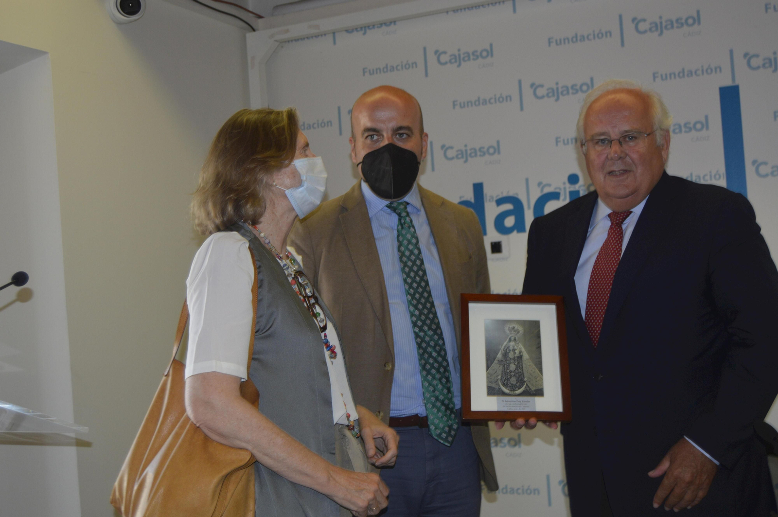 El hermano mayor de la Hermandad del Carmen, Pablo Durio, entregando un cuadro de la Virgen del Carmen a Estanislao Pery y su mujer María Osborne, tras la presentación.