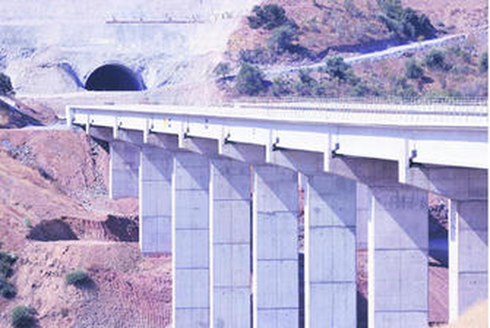 Un puente y de la entrada de un túnel inacabados y sin trabajadores de la futura autopista de Las Pedrizas.