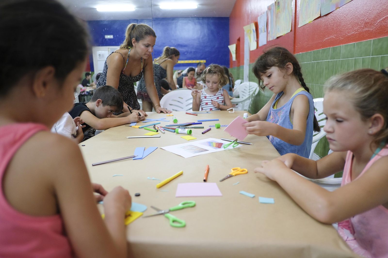 Rocío Banda atiende a algunos de los niños que participan en el campamento urbano mientras hacen manualidades.