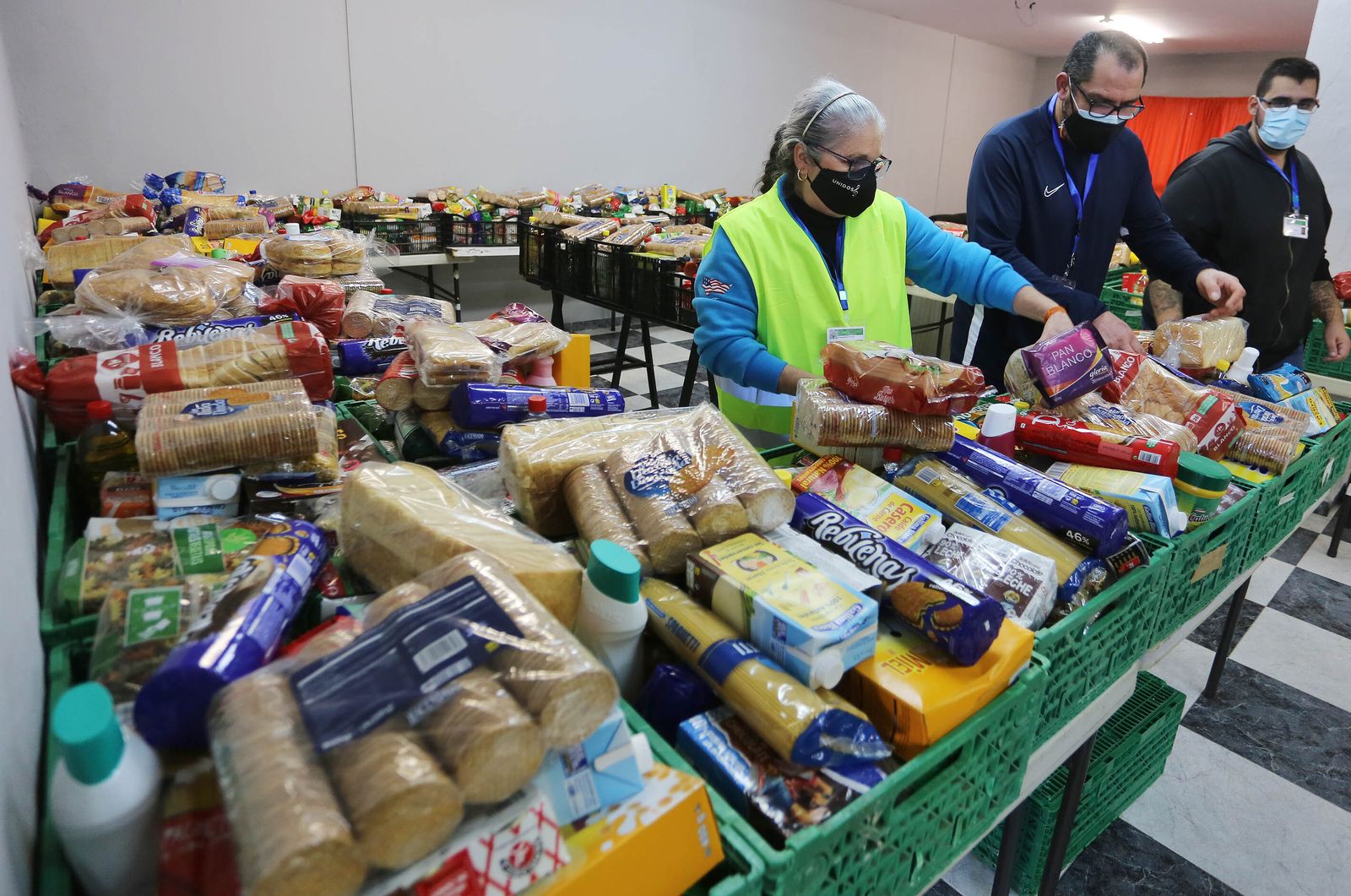 Voluntarios de 'Unidos por la música' preparan las cajas de alimentos para repartir entre las familias.