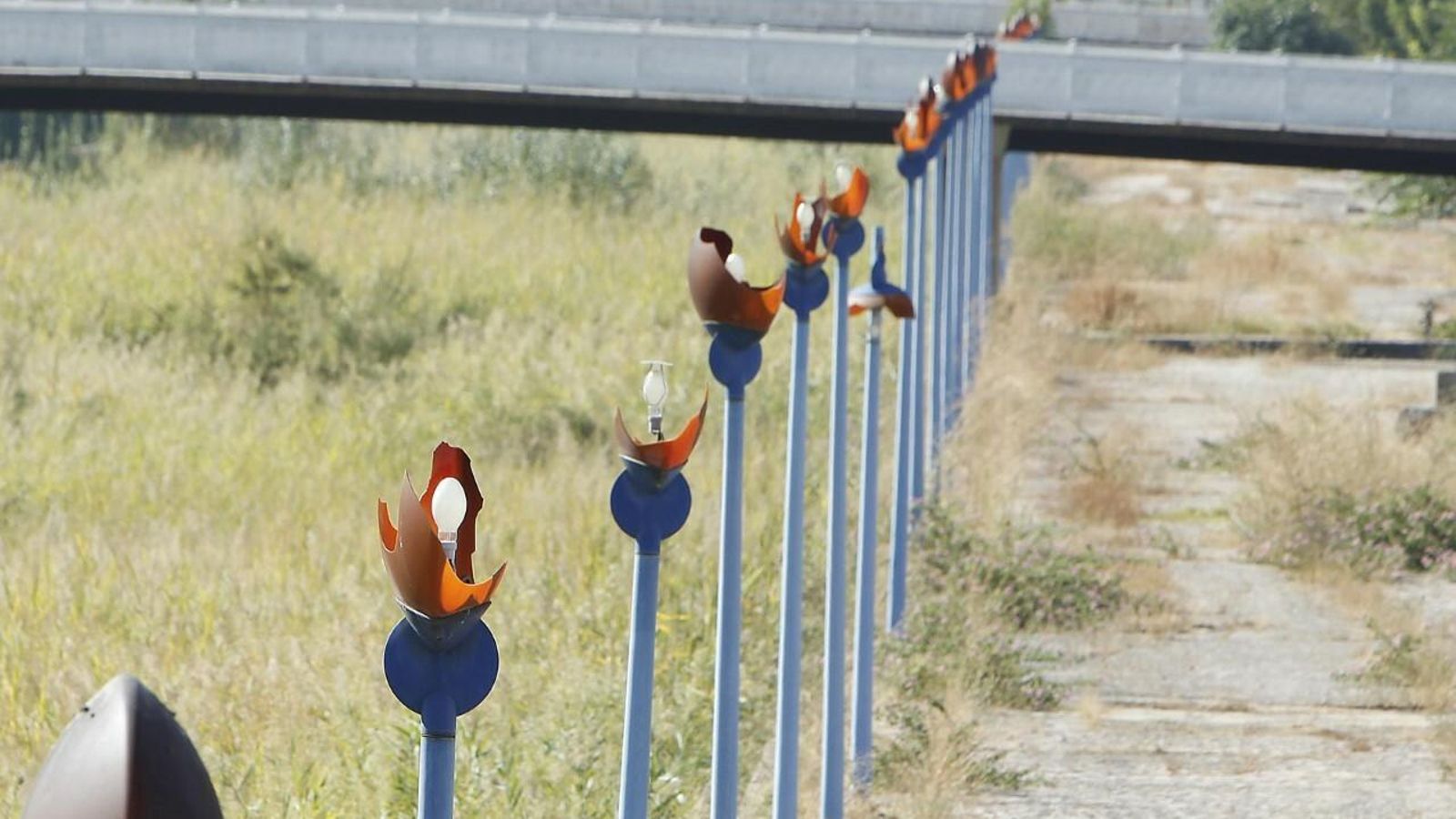 Farolas instaladas hace 27 años y rotas lucen aún junto al canal seco de la Cartuja, imagen de abandono.