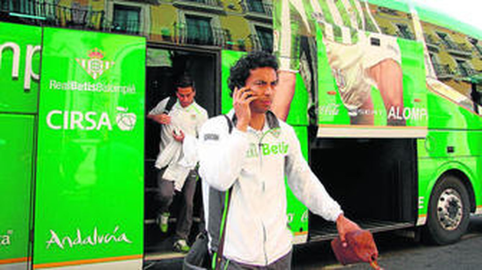 Iriney habla por teléfono, tras bajarse del autobús del Betis.