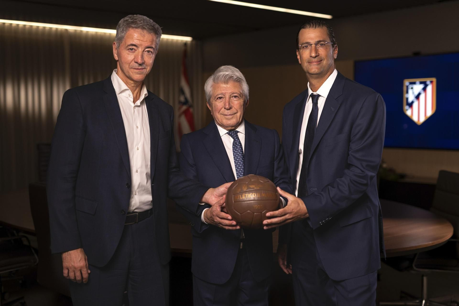 El consejero delegado del Atlético de Madrid Miguel Ángel Gil (i), y el presidente del equipo, Enrique Cerezo (c), posan junto a Robert Givone (d), socio de Apollo y co-gestor de ASC Apollo Sports Capital (ASC).