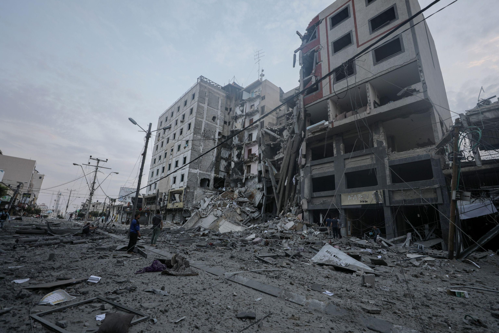 Dos palestinos miran un edificio destruido por los bombardeos. Dos palestinos miran un edificio destruido por los bombardeos.