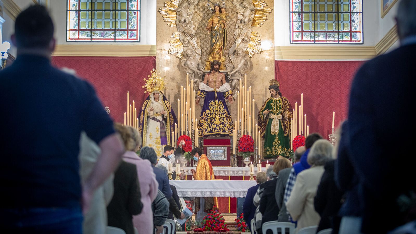Un sacerdote oficia una misa en Salesianos, ante las imágenes de la cofradía del Despojado.