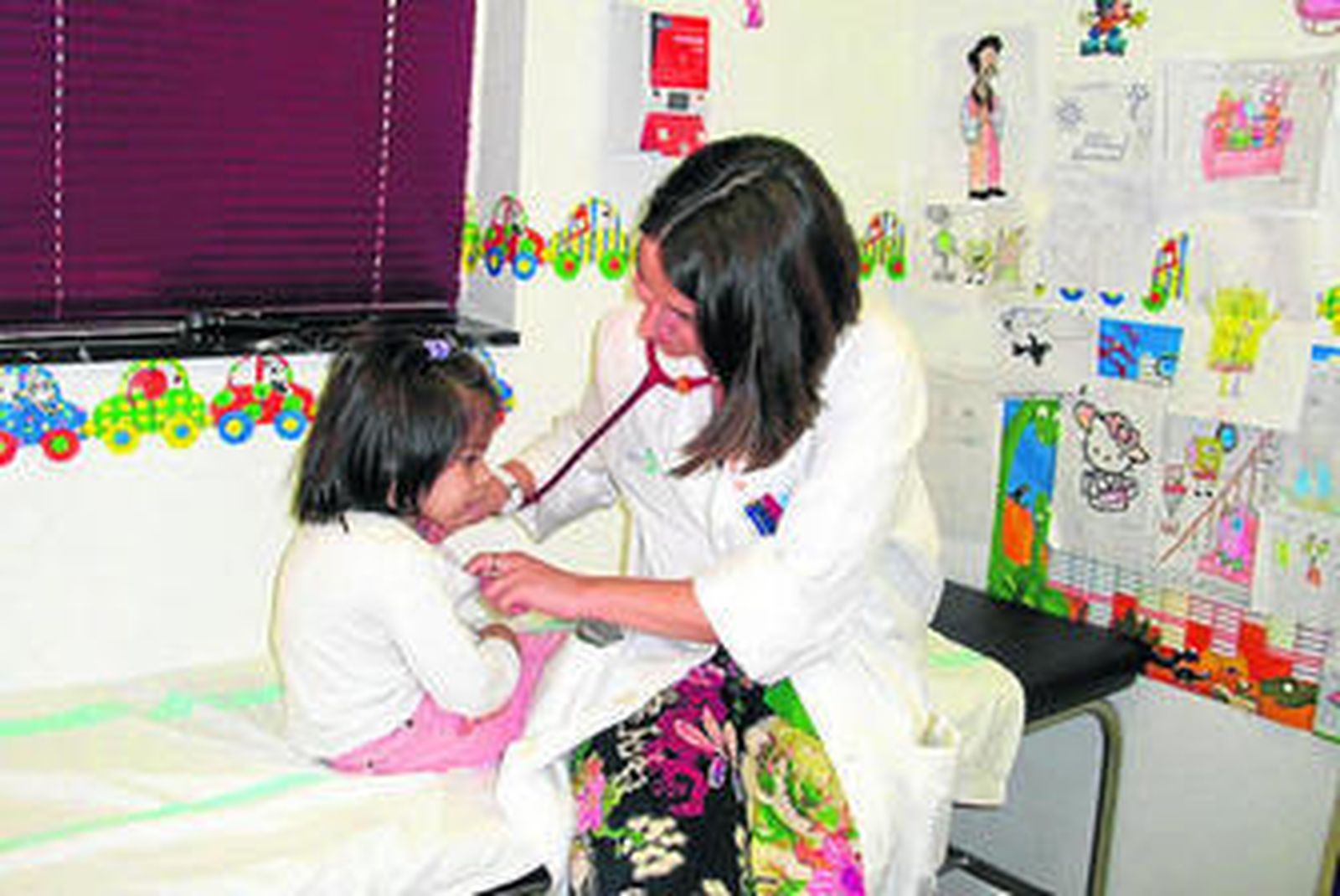 Una pediatra ausculta a una niña.