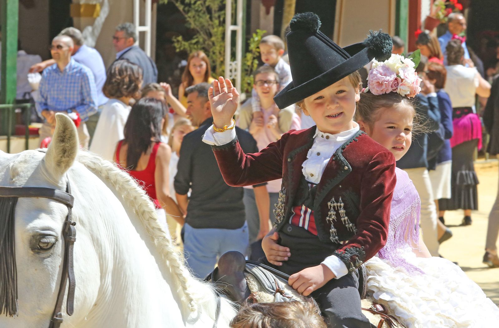 Dos pequeños montan perfectamente vestidos.