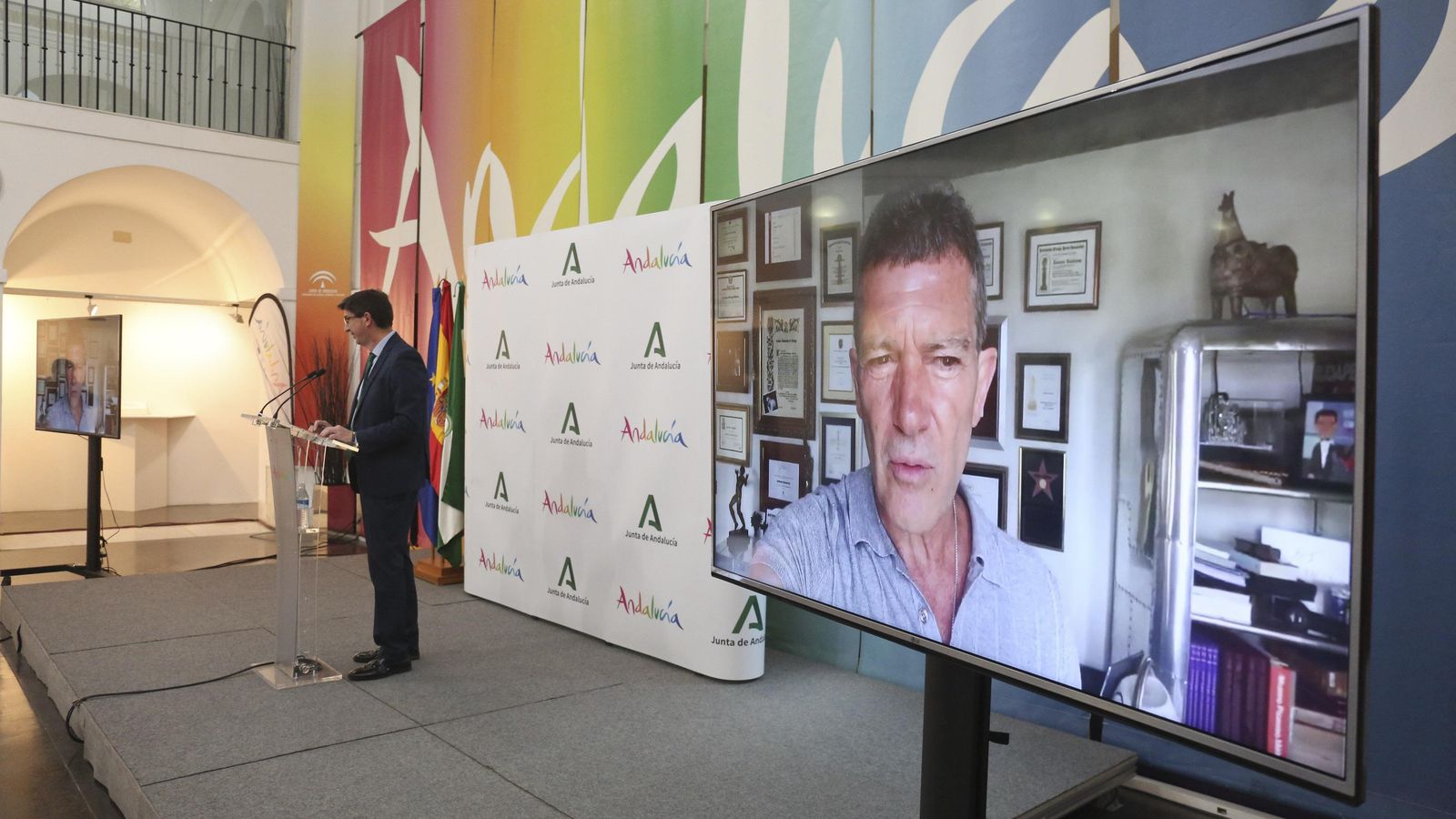 Antonio Banderas, en primer plano, en su mensaje en vídeo y al fondo el consejero de Turismo. Antonio Banderas, en primer plano, en su mensaje en vídeo y al fondo el consejero de Turismo.