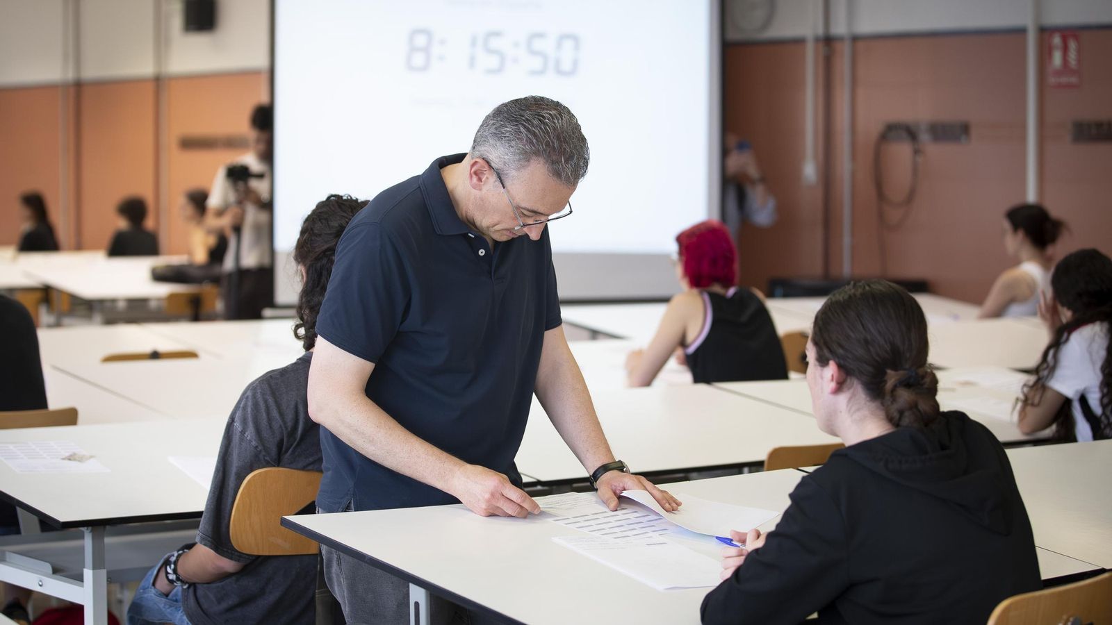 Un profesor entrega los exámenes de Lengua y Literatura II.