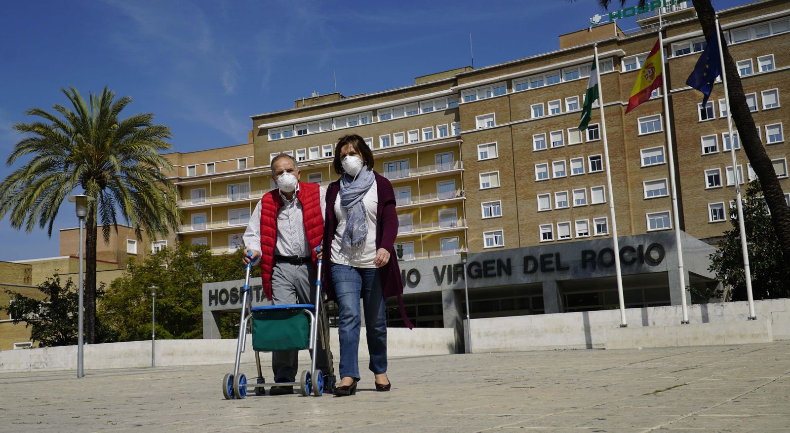 Dos personas salen del Hospital Virgen del Rocío, en Sevilla.