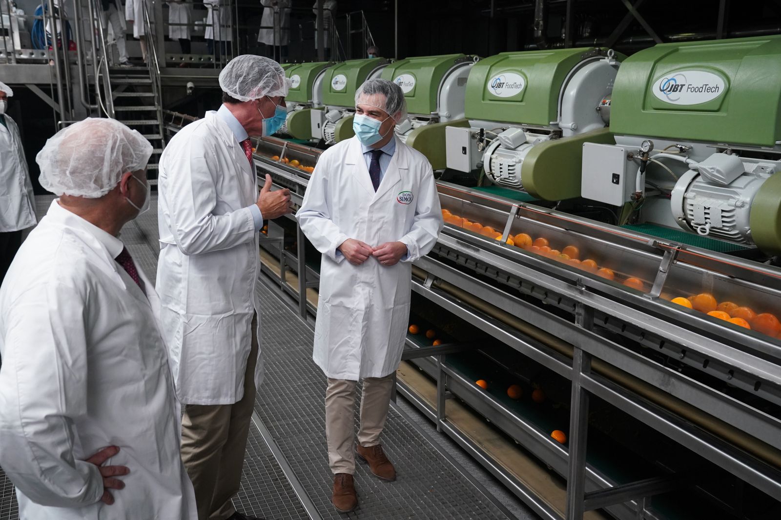 Juanma Moreno, durante la visita a la planta de J. García Carrión en Villanueva de los Castillejos.