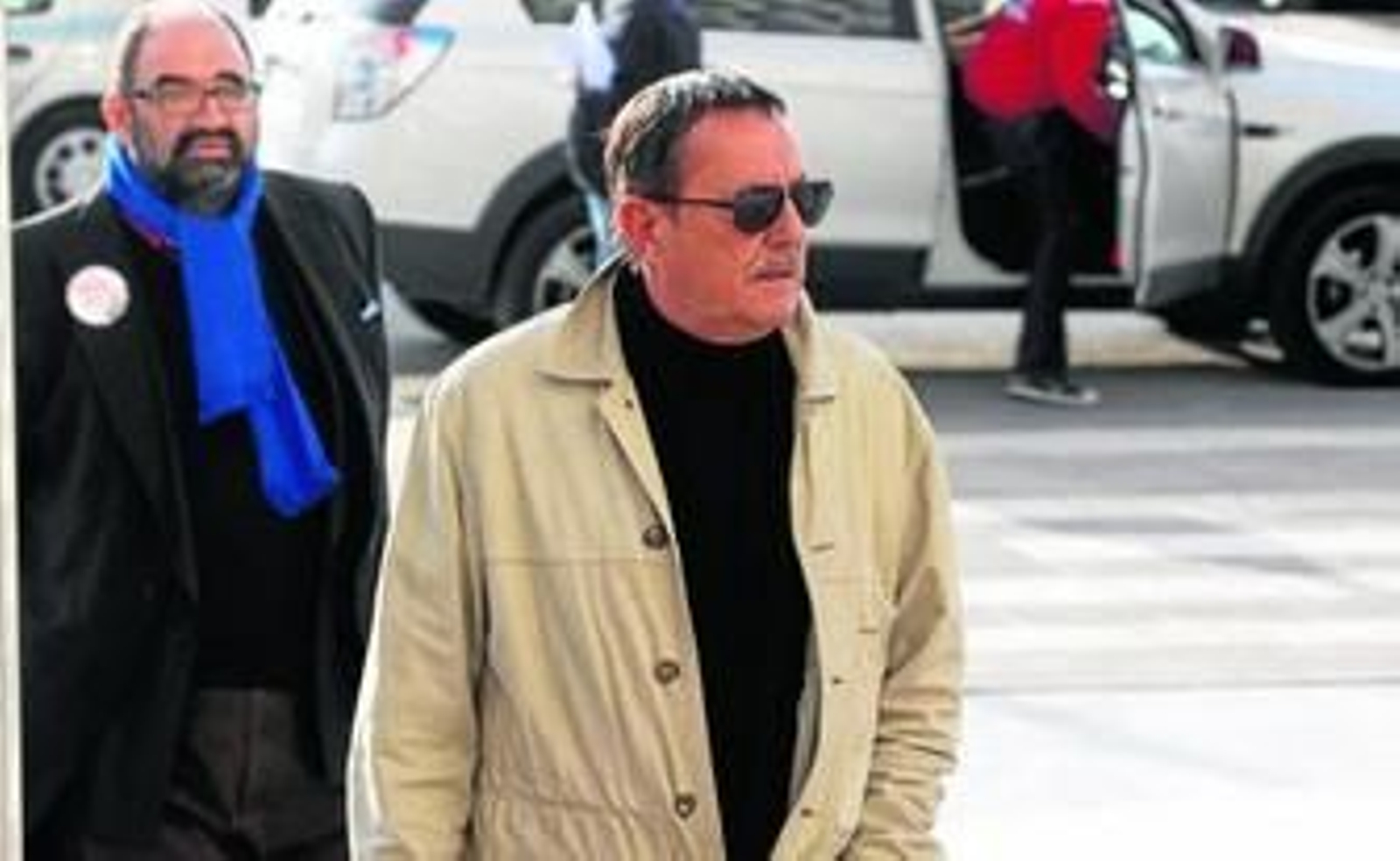 Julián Muñoz, a la entrada de la Ciudad de la Justicia. Detrás, El mocito feliz, singular personaje malagueño dedicado a seguir a figuras de la televisión.