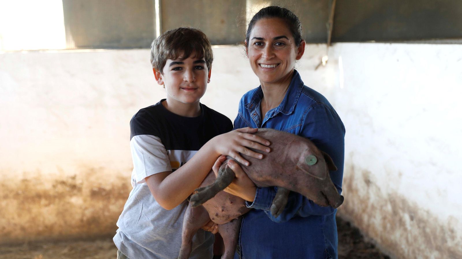 Ana Álvarez y su hijo Bernardo sostienen un lechón. Ana Álvarez y su hijo Bernardo sostienen un lechón.