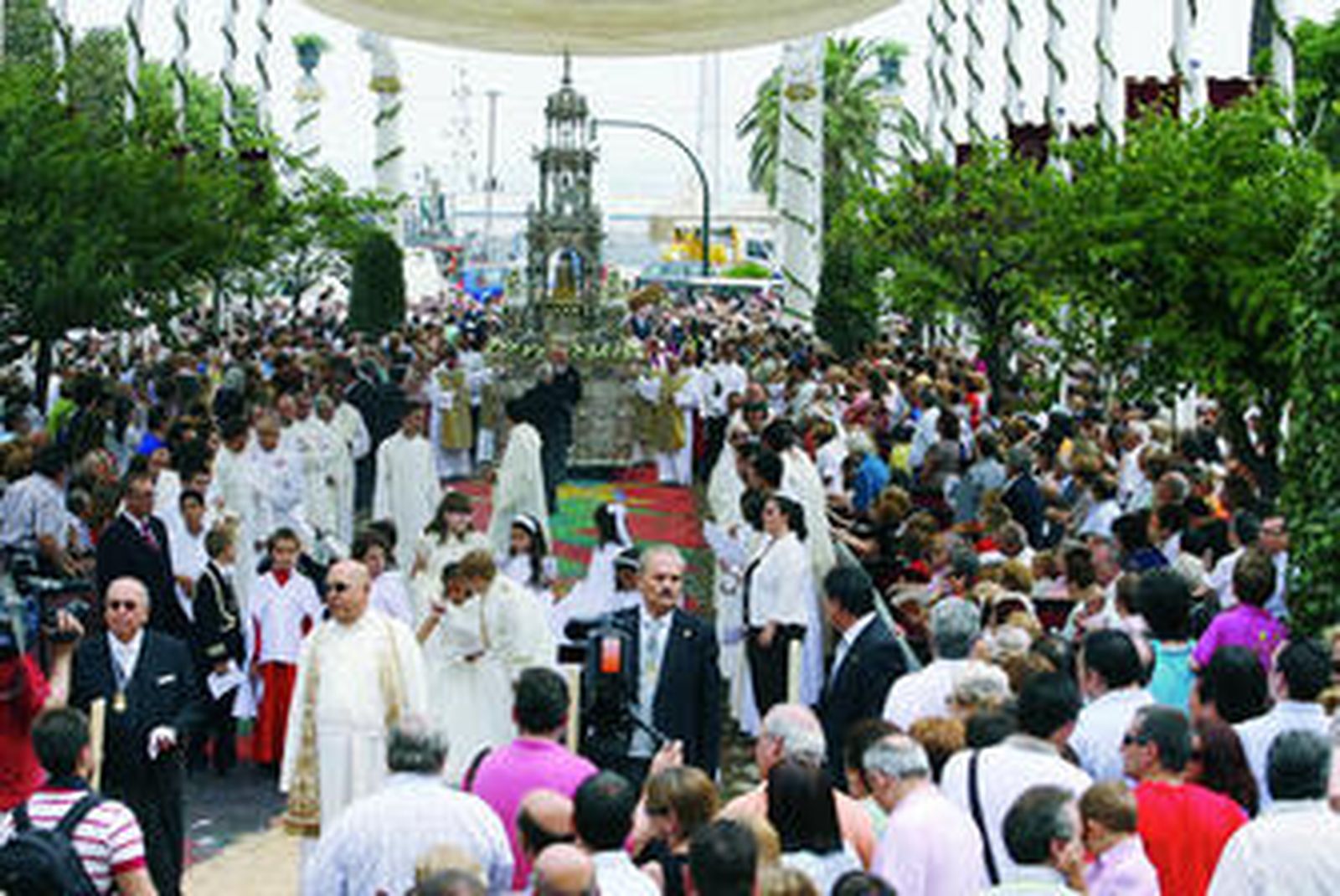 La custodia con el Santísimo a su paso sobre la alfombra de serrín montada en la plaza de San Juan de Dios por los grupos jóvenes de las hermandades.