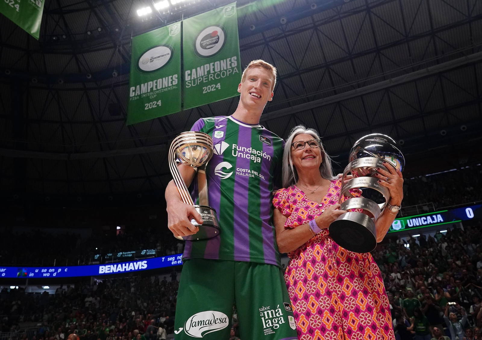 Alberto Díaz y Toñi García, con los trofeos y las banderas al fondo.