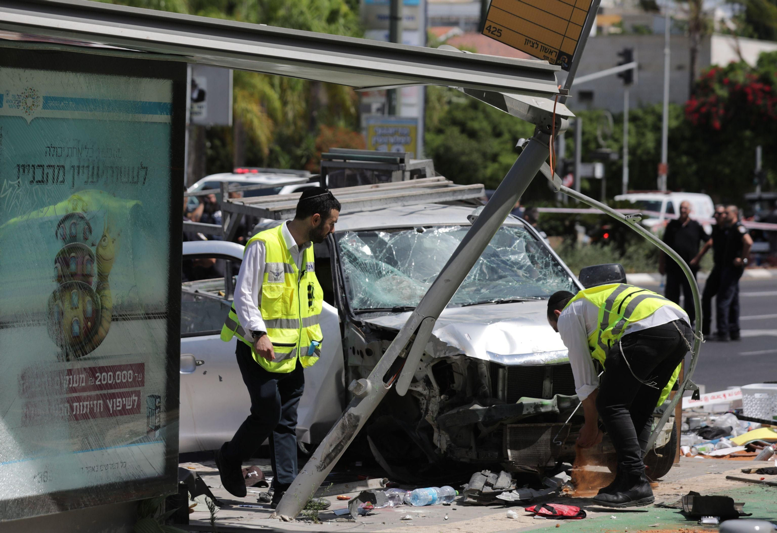 Miembros de los equipos de emergencias trabajan en el lugar donde se produjo un atropello múltiple en Tel Aviv.
