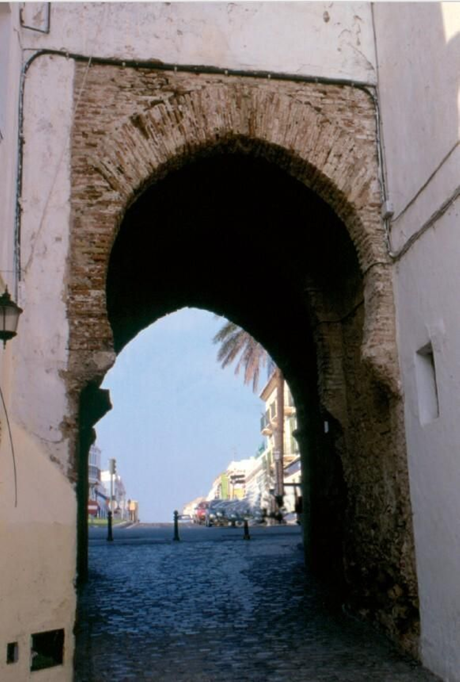 La puerta de Jerez de la cerca de Tarifa, de ingreso recto y arco de herradura apuntado, vista desde la zona intramuros. La puerta de Jerez de la cerca de Tarifa, de ingreso recto y arco de herradura apuntado, vista desde la zona intramuros.