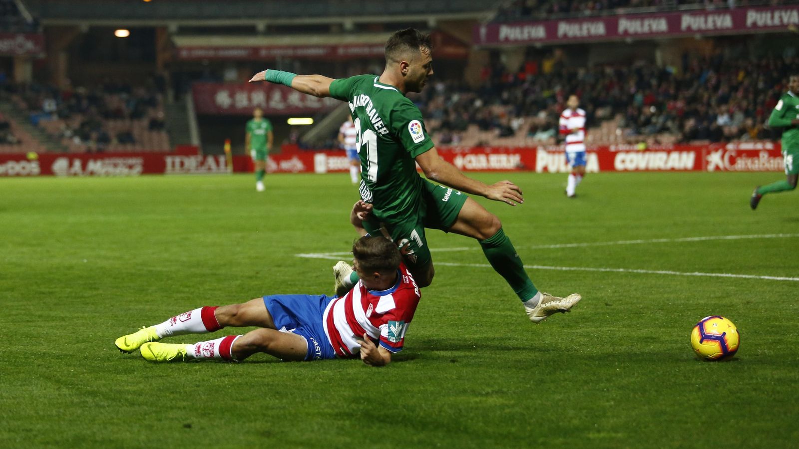 Alejandro Pozo cae ante Traver, que fue el autor del tanto del Sporting en Los Cármenes.