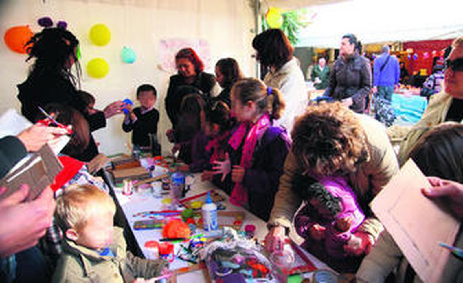 1 y 3. Decenas de pequeños realizan las manualidades bajo la tutela de los animadores y la atenta mirada de sus padres, que no quieren perderse detalle. 2. Un pequeño enseña a su padre el portarretrato que ha confeccionado con sus manos.