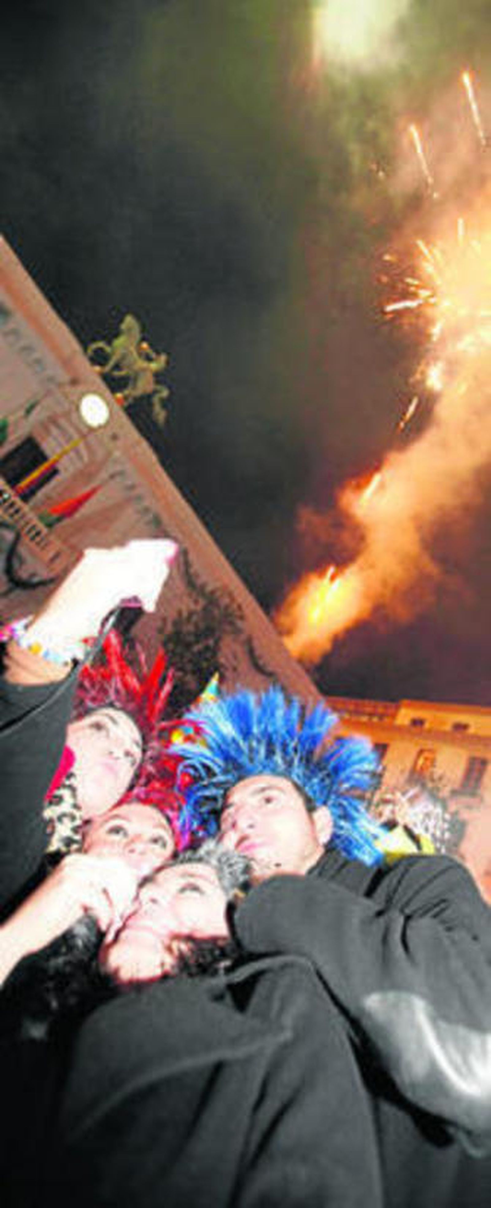 Un grupo de amigos disfruta de los fuegos artificiales en la plaza del Carmen.