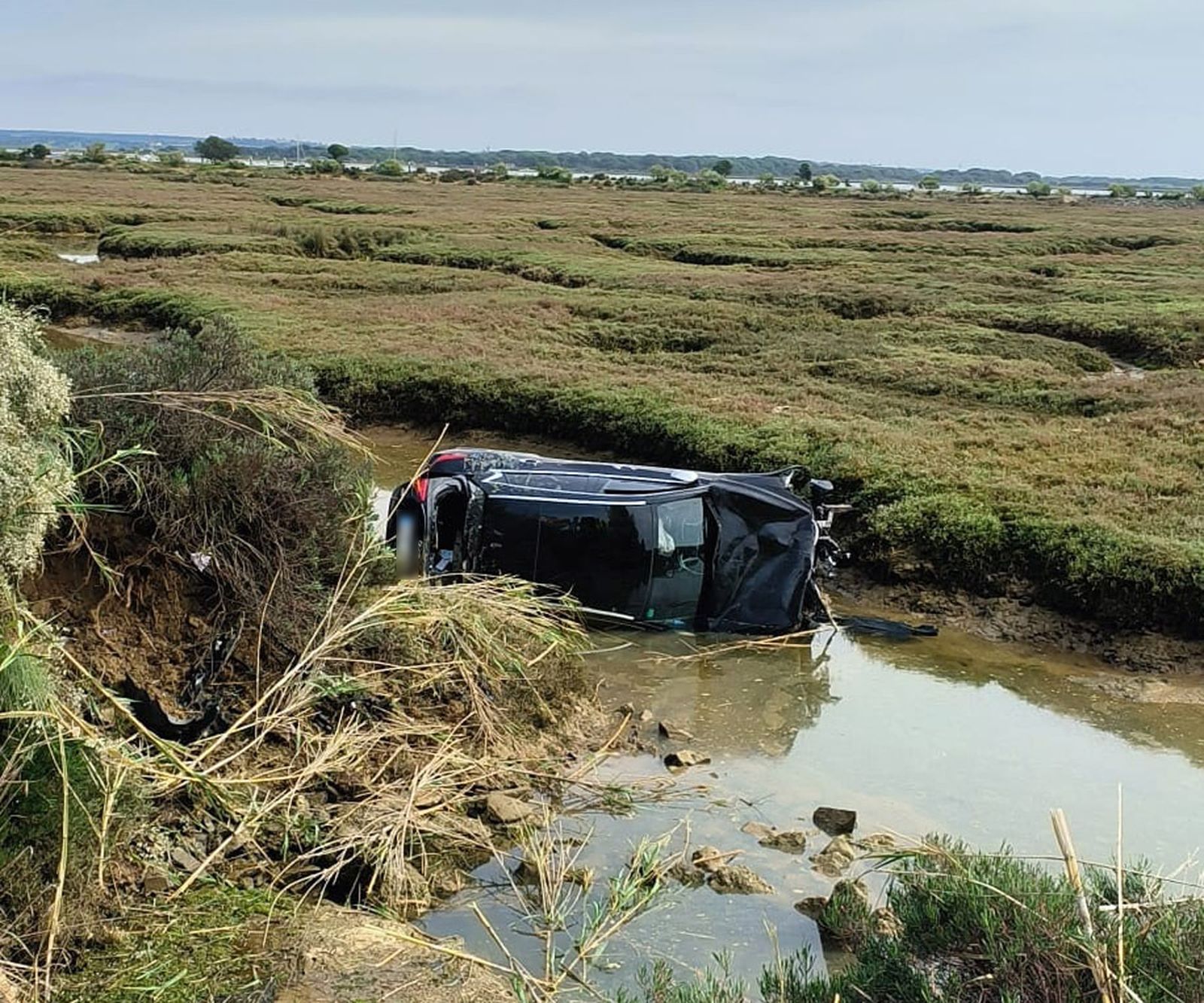 El turismo fue a parar a un estero de la marisma tras salirse de la calzada