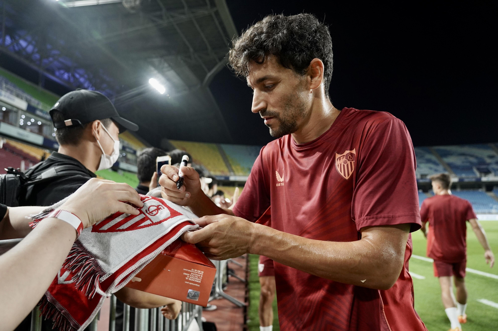 Jesús Navas firma autógrafos tras el entrenamiento en el estadio de Suwon.