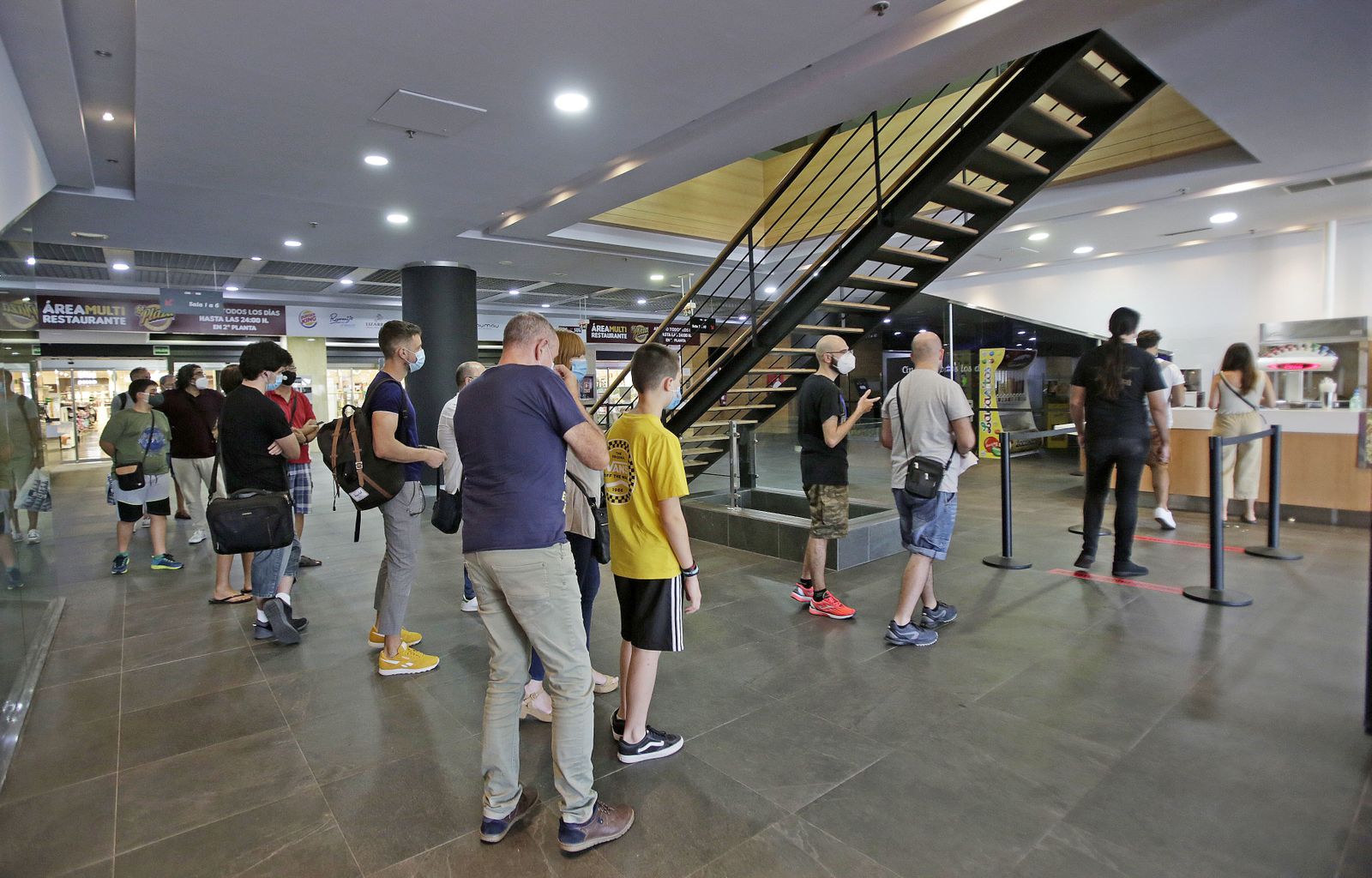 Un grupo de espectadores guarda cola en la taquilla de Cinesur en Cádiz, en el centro comercial de El Corte Inglés.