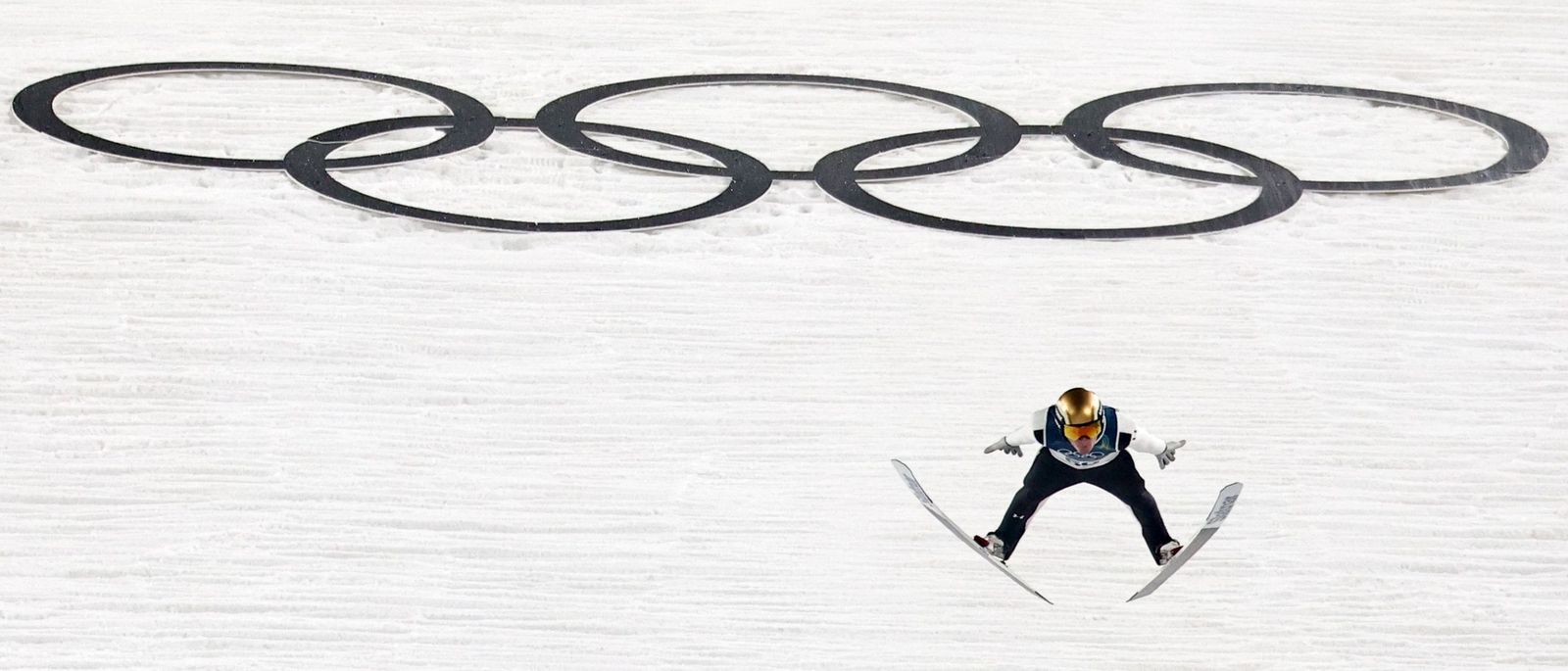 El gran Domen Prevc vuela con los aros olímpicos de fondo.