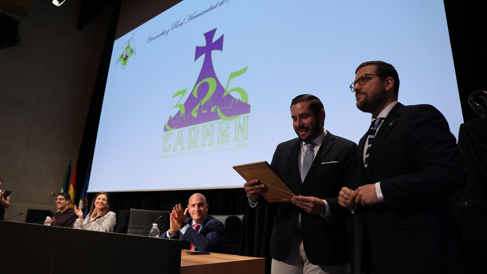 Presentación de logotipo del 325 aniversario fundacional de la hermandad del Carmen de San Fernando, obra de Pablo Moreno. En la imagen, el autor recoge un presente a modo de agradecimiento que le entrega el hermano mayor de la hermandad, Juan José Richarte. Presentación de logotipo del 325 aniversario fundacional de la hermandad del Carmen de San Fernando, obra de Pablo Moreno. En la imagen, el autor recoge un presente a modo de agradecimiento que le entrega el hermano mayor de la hermandad, Juan José Richarte.