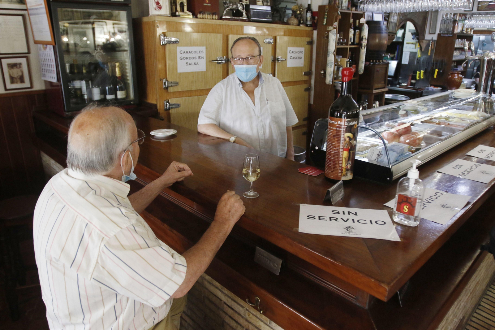 Un hombre toma una copa de vino en una barra de un bar de Córdoba.