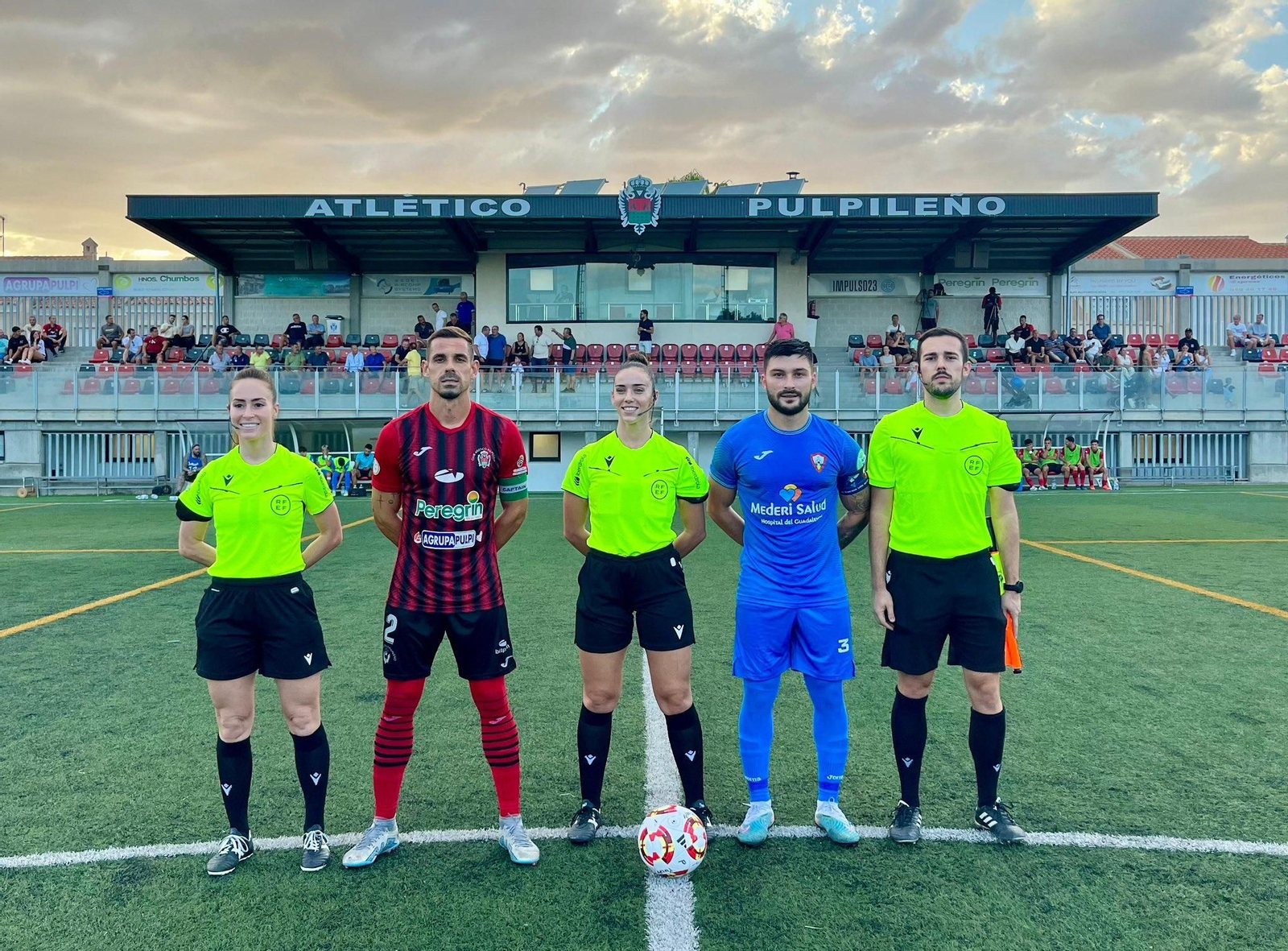 Los dos capitanes de ambos equipos, junto con el trío arbitral.