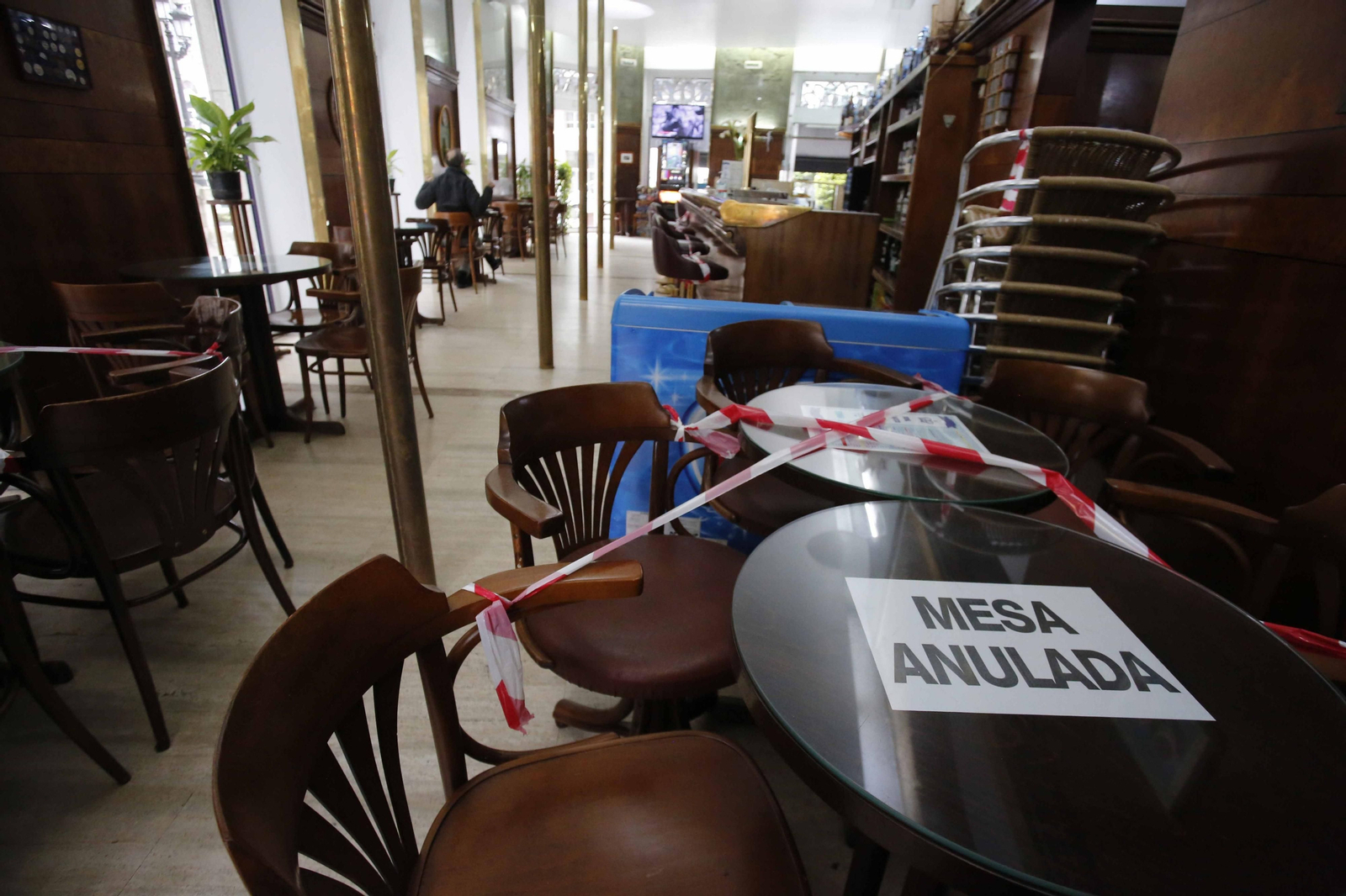 Interior de un bar con varias mesas precintadas para mantener la distancia de seguridad.