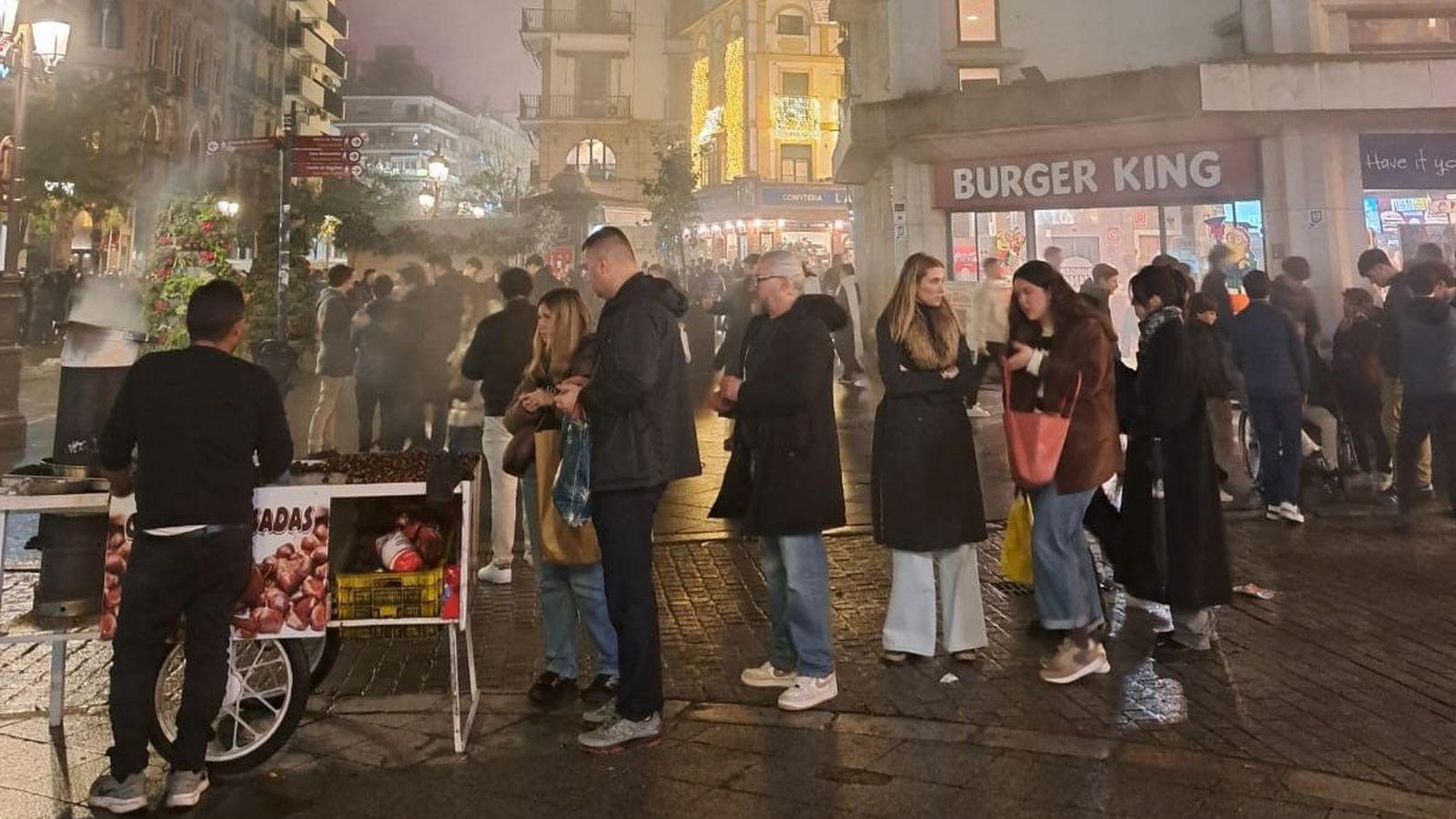 Cola en un puesto de castañas asadas en la Campana