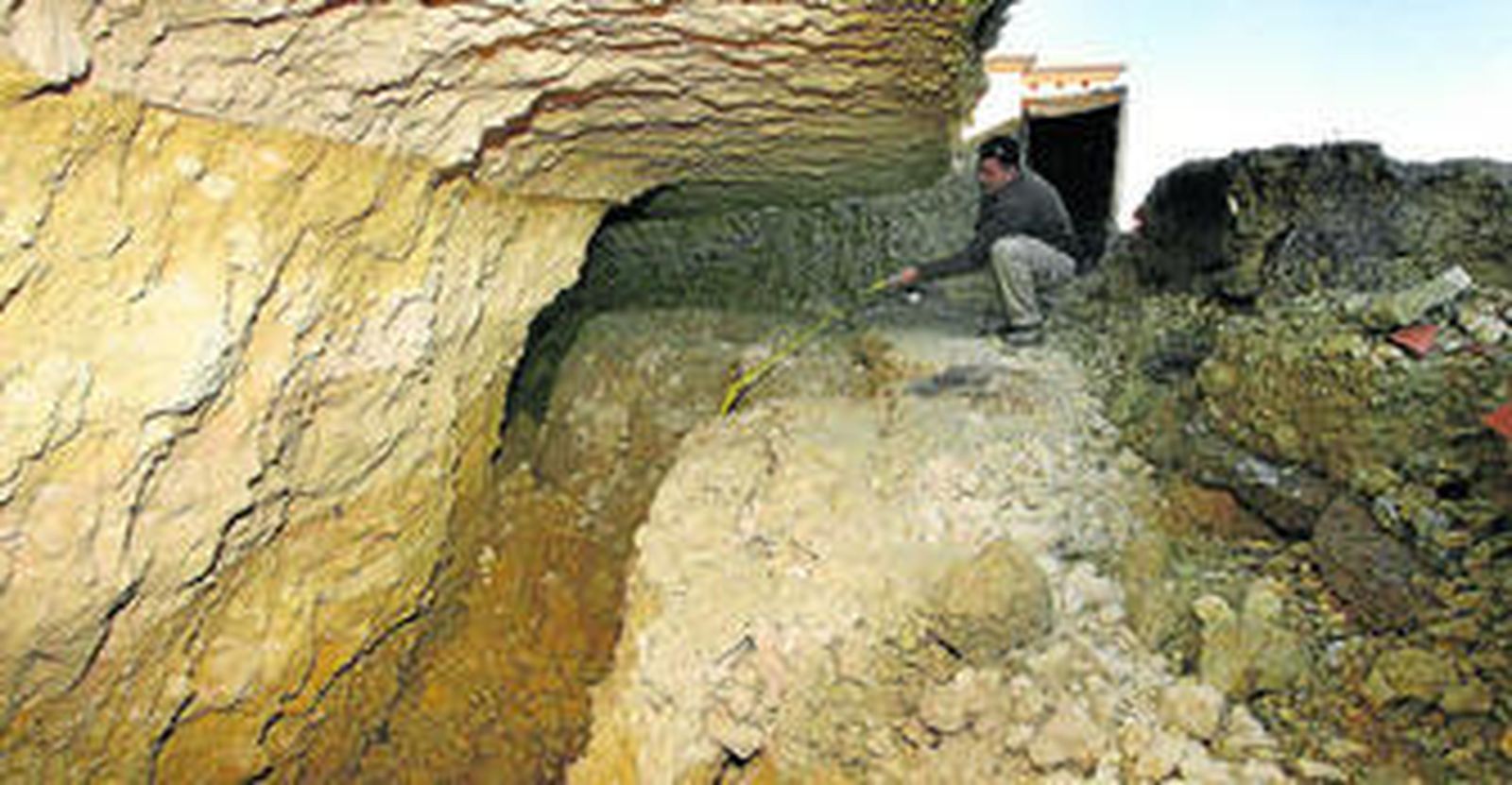 Francisco Pozo, operario de la zona, muestra la falta de sujeción de los cimientos de las viviendas afectadas a la loma donde están construidas.