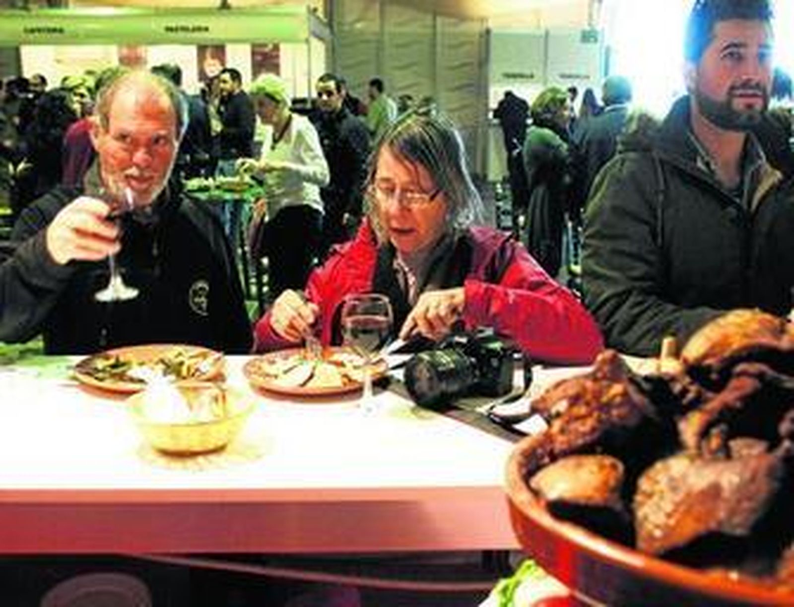 Dos turistas, disfrutando ayer de los chicharrones, en uno de los establecimientos asociados a la muestra.
